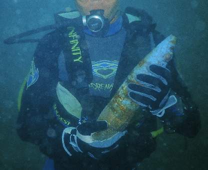 High Explosive large caliber shell being played with by a recreational scuba diver. Prat.
